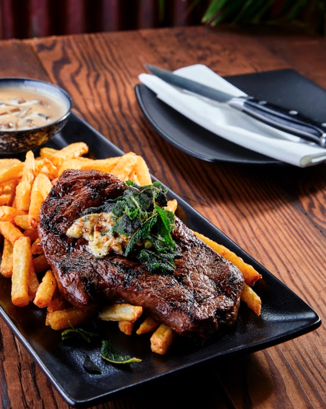 Ribeye steak with herb butter and fries at Jozi Gin